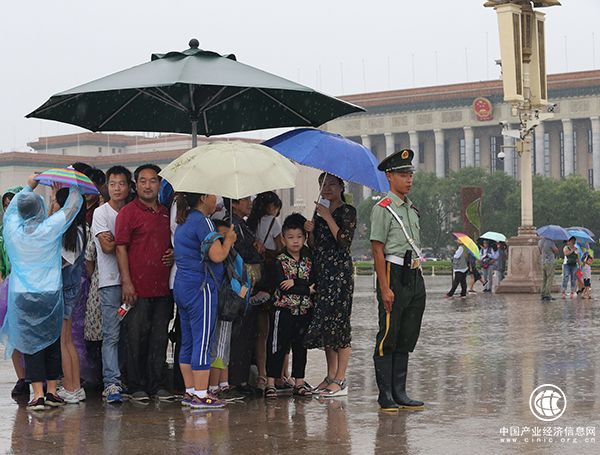 天安門廣場一執(zhí)勤武警將崗傘讓給群眾避雨，自己冒雨站崗