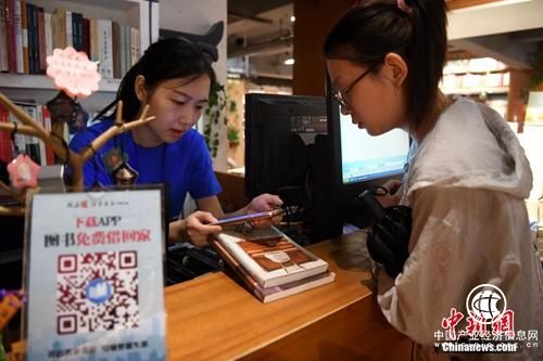 資料圖：書店工作人員幫讀者辦理共享圖書借閱。安徽省合肥市新華書店三孝口店“變身”為共享書店，讀者只需繳納99元押金就可免費(fèi)把書從書店帶回家閱讀。<a target=