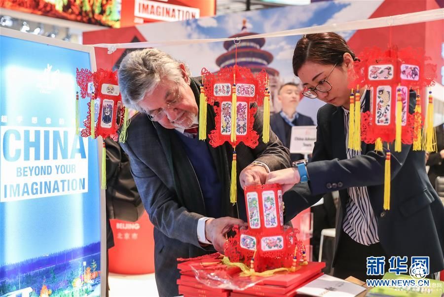 中國(guó)展區(qū)的工作人員為參觀者制作紙燈籠